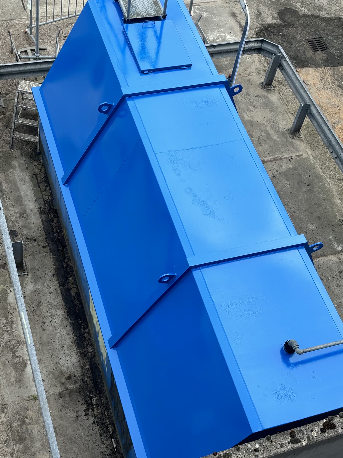 Dezelfde silo van bovenaf na het schilderwerk, egaal helderblauw